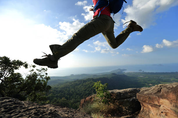 istock jumping over precipice between two rocky mountains at sunset 667453510