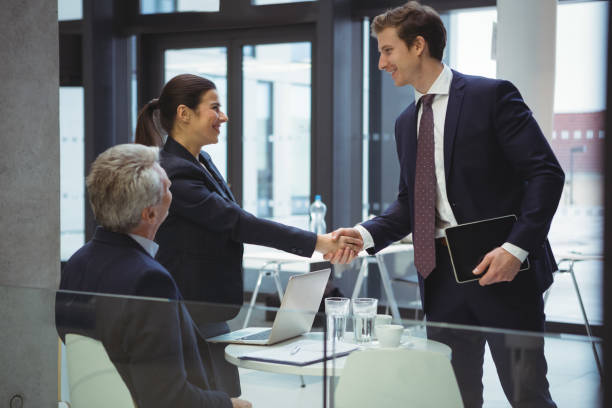 istock Businesspeople shaking hands in a lobby 667457028