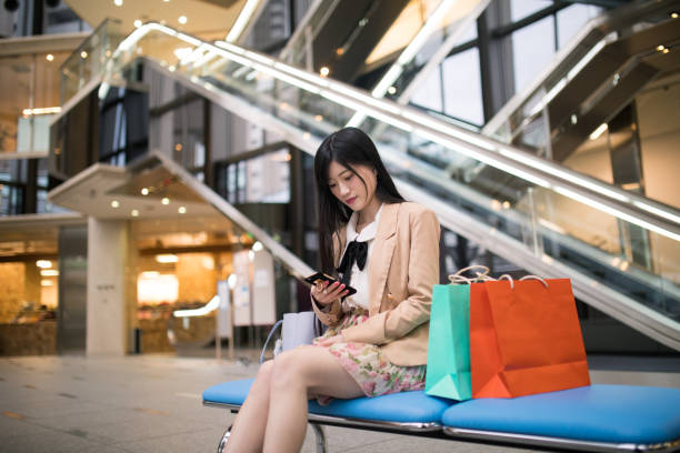 istock Young woman checking e-mails on smart phone in city 667457170