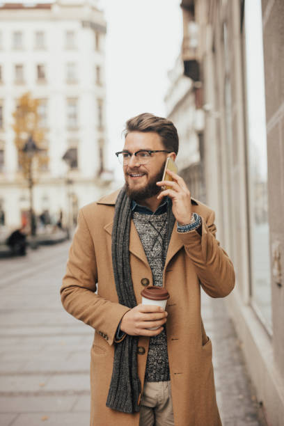 istock Happy young hipster walking in town and talking on mobile phone 667457624