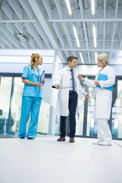 istock Medical team interacting with each other in corridor 667458490