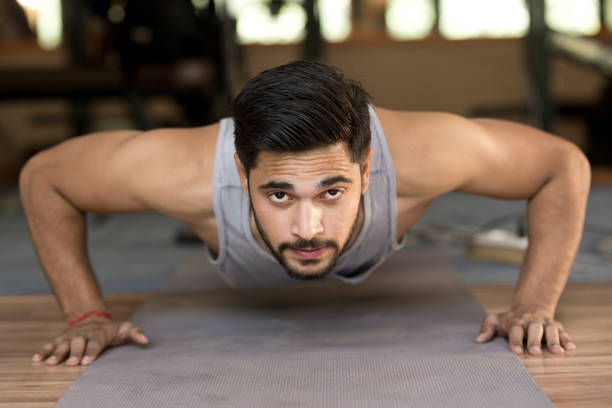 forma joven haciendo flexiones de brazos - body building gym human muscle effort fotografías e imágenes de stock