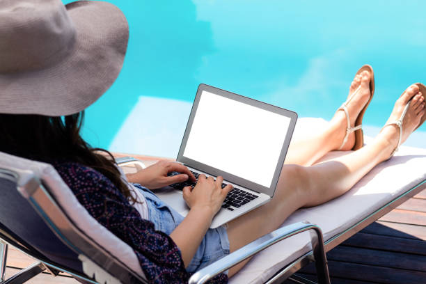 istock Woman sitting on deckchair using laptop 667471032