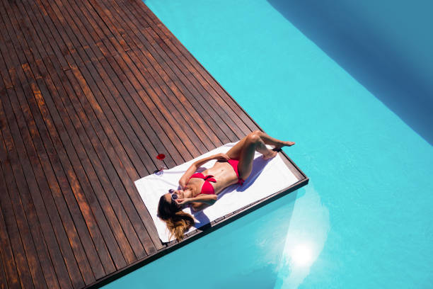 istock Woman enjoying sunbath on the pool edge 667482190