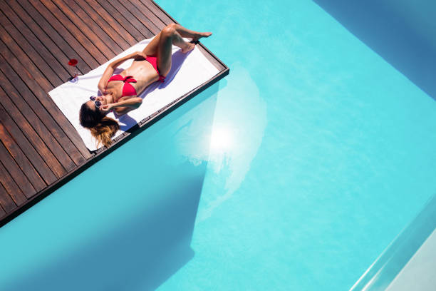 istock Woman enjoying sunbath on the pool edge 667482294