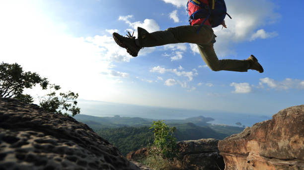istock jumping over precipice between two rocky mountains at sunset 667482378