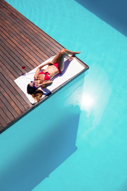 istock Woman enjoying sunbath on the pool edge 667482460