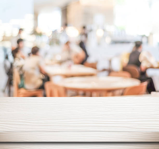 istock Empty white wood table and blurred cafe with bokeh light background, food and product display montage 667485872