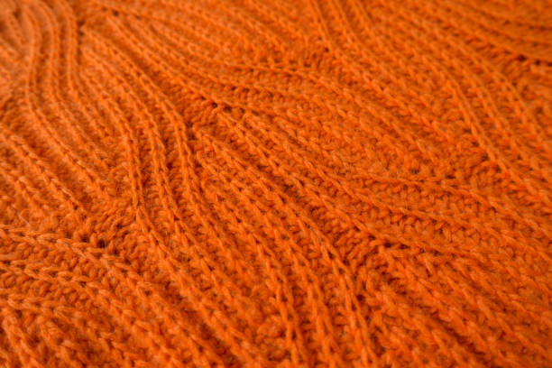 istock Close-up of bright orange handmade knit fabric with plait pattern (diagonal) 667491216