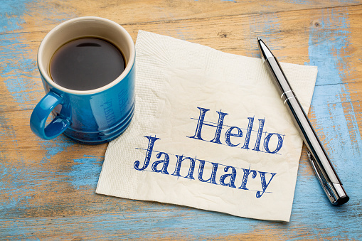 Hello January - handwriting on a napkin with a cup of coffee