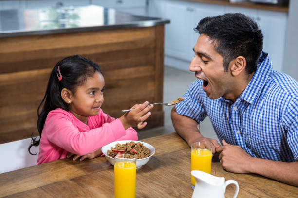 istock Cute daughter feeding his father 667502756