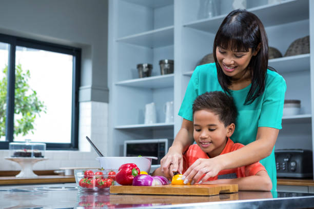 istock Smiling mother cooking with her son 667503026
