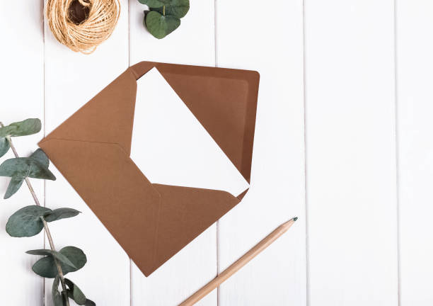 istock Blank envelope, pencil and eucalyptus brunches on the white tabl 667510604