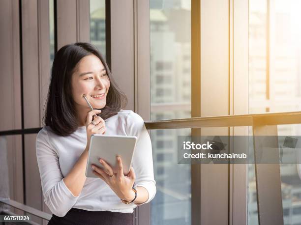 Smile Business Woman Is Thinking With Tablet In Modern Office Stock Photo - Download Image Now