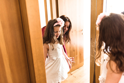 mother and daughter dressing up at the mirror