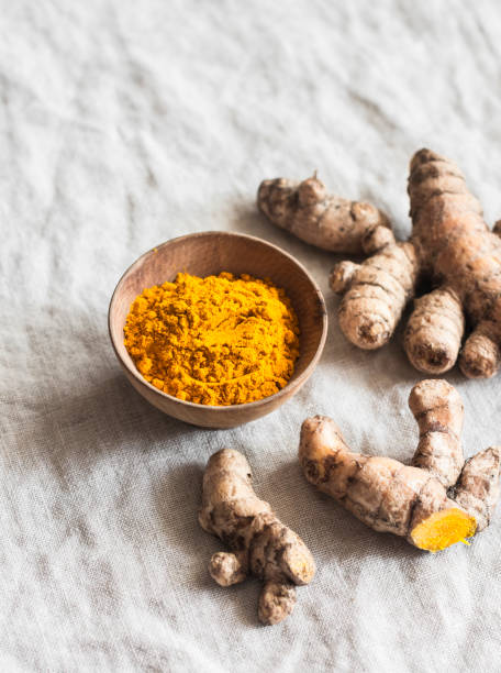 Turmeric root and turmeric powder on a light background