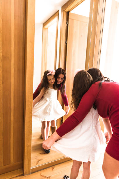 istock mother and daughter dressing up at the mirror 667523180