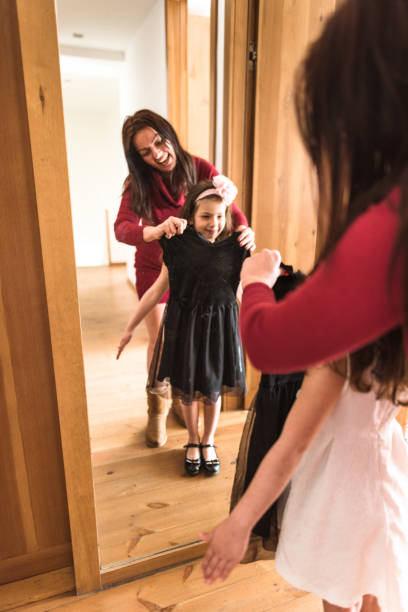 istock mother and daughter dressing up at the mirror 667535832