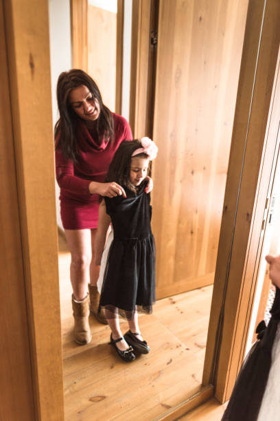 istock mother and daughter dressing up at the mirror 667536192