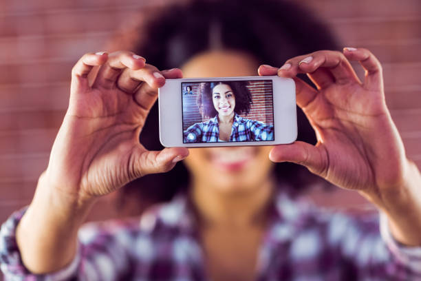 istock Attractive young woman taking selfies with smartphone 667536930