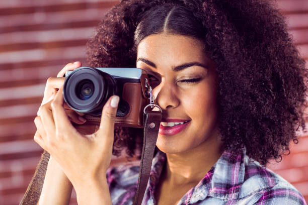 istock Attractive young woman photographing with camera 667540022