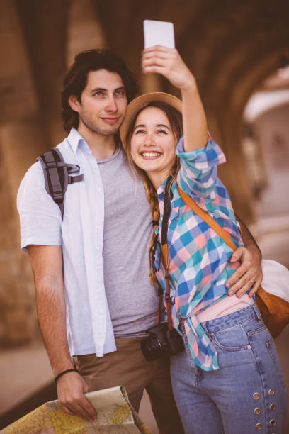 istock Young couple taking a selfie under medieval arches 667541494