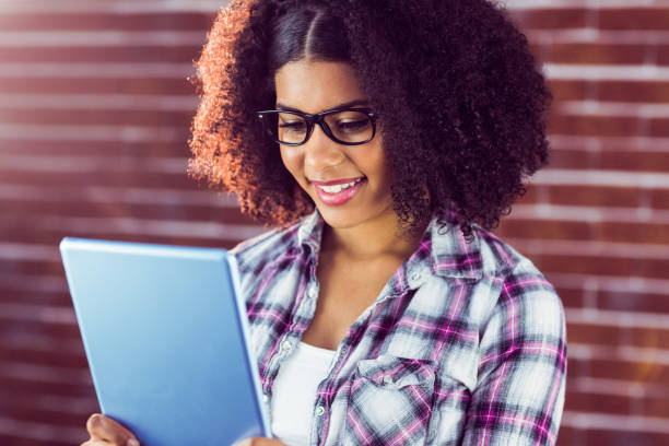 istock Attractive hipster smiling and looking at tablet 667541932