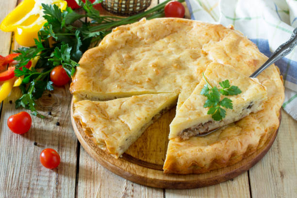 istock A classic quiche Lorraine pie with potatoes, cabbage, fish and cheese on a wooden table. 667542254