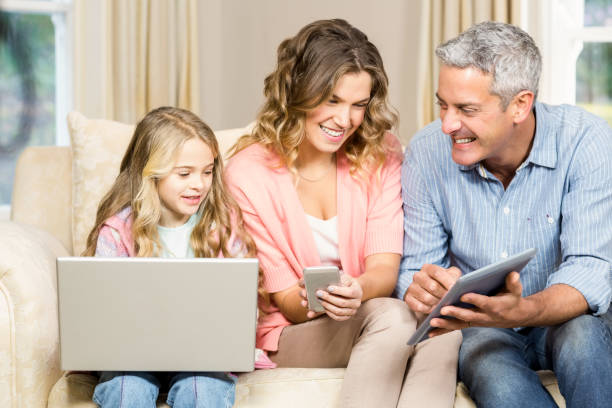 istock Happy family using laptop, tablet and smartphone 667542286