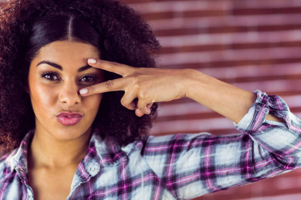 istock Attractive young woman showing peace sign 667544852