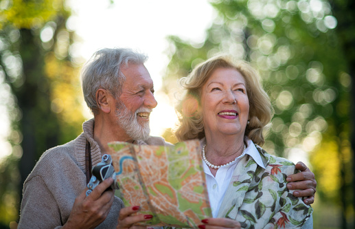 Smiling senior couple using map at the nature