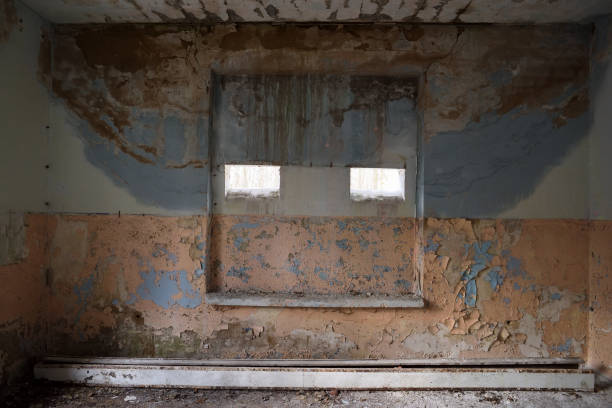 istock Old painted wall in abandoned building with small windows 667567918