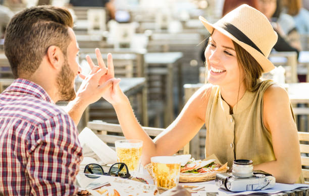 pareja de enamorados que se divierten en el bar de la cerveza en concepto de viaje excursión - jóvenes turistas felices disfrutando el momento feliz en el restaurante de comida de la calle - relación con foco en la cara de la chica caliente filtro brill - italiano idioma fotografías e imágenes de stock