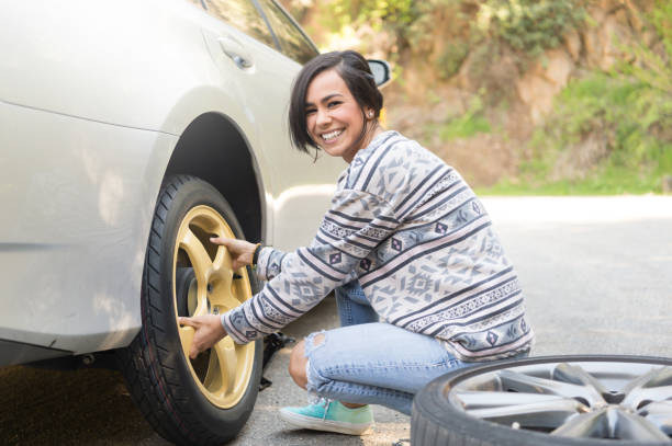 istock Young Women Changing A Flat Tire 667577474