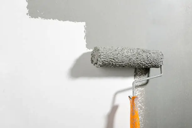 Close-up of paint roller on the wall.