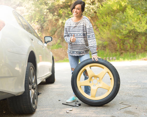 istock Young Women Changing A Flat Tire 667578396