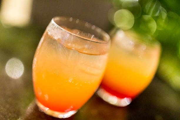 Close-up of two glasses of Tequila sunrise cocktails just waiting to be savoured. Refreshing drinks. tequila sunrise stock pictures, royalty-free photos & images