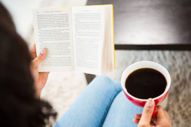 istock Cropped image of woman with coffee reading book 667581190