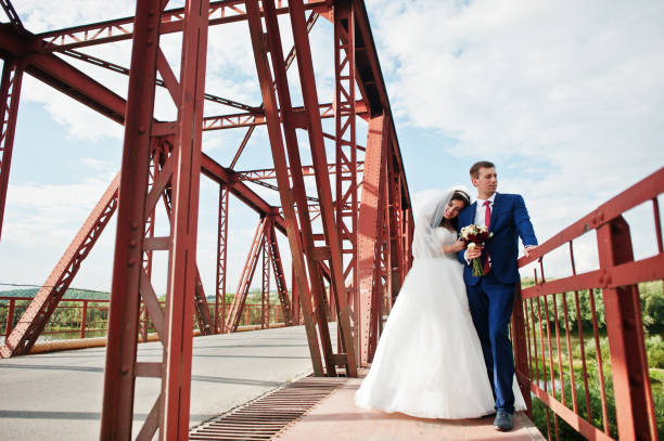 istock Wedding couple in love stay at red railway bridge. 667587964