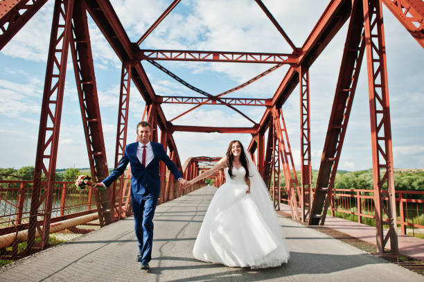 istock Wedding couple in love stay at red railway bridge. 667587992