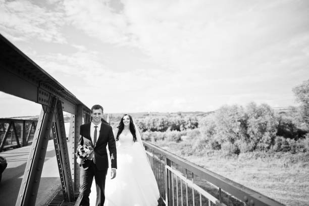 istock Wedding couple in love stay at red railway bridge. 667588018