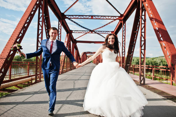 istock Wedding couple in love stay at red railway bridge. 667588034