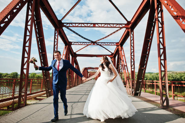 istock Wedding couple in love stay at red railway bridge. 667588038