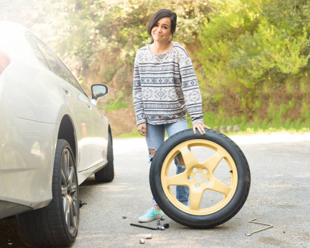 istock Young Women Changing A Flat Tire 667588444