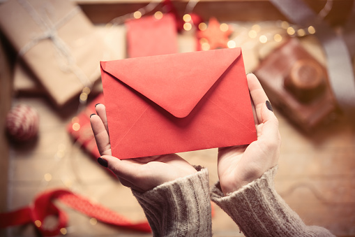 beautiful woman hands holding big red envelope on the wonderful  decoration background