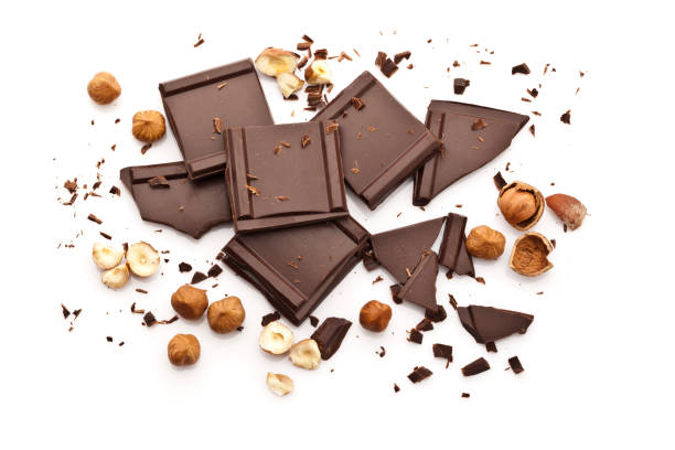 istock Chocolate pieces and hazelnuts isolated on white background 667591312