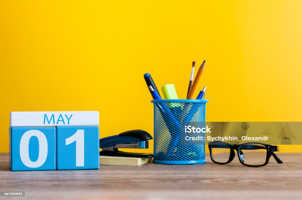 1º de maio. dia 1 do mês, calendário de mesa de escritório de negócios, local de trabalho no fundo amarelo. Tempo de primavera - Foto de stock de A Data royalty-free