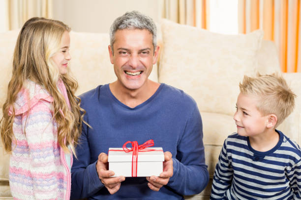 istock Happy father holding gift given by children 667593336