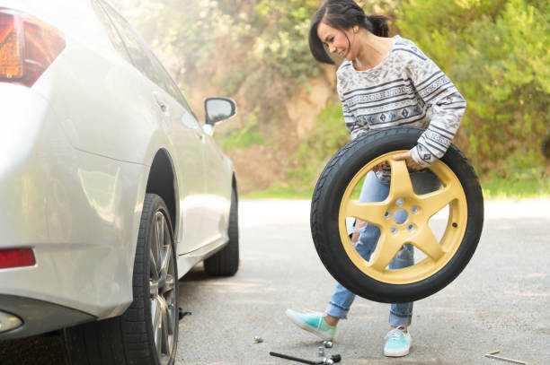 istock Young Women Changing A Flat Tire 667596102