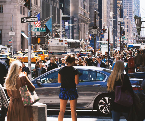 Rush hour in New York City New York City, United States - April 16, 2016: commuters walking down 5th Avenue at rush hour. Fifth Avenue is a famous shopping area in Manhattan. This is also where the world-renowned museums Metropolitan and Guggenheim are situated as well as some of the finest apartment buildings in New York City. The avenue offers a variety of sites of interest that attract  both tourists and locals every day. walking point of view stock pictures, royalty-free photos & images